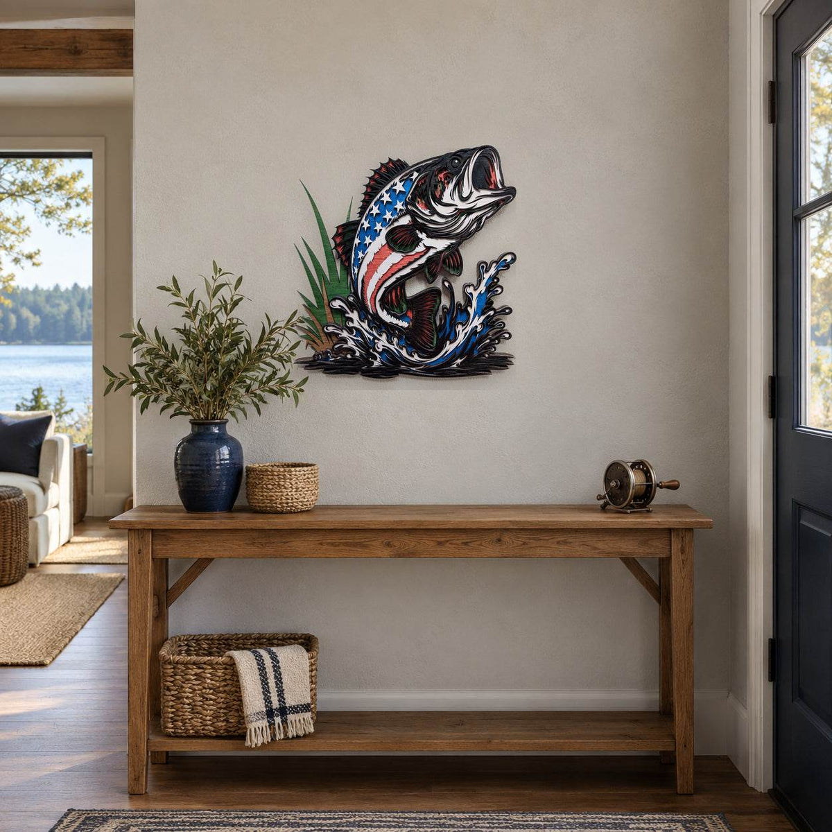 A decorative metal wall art piece of a jumping fish with an American flag pattern, displayed on a beige wall above a wooden console table in a styled entryway.