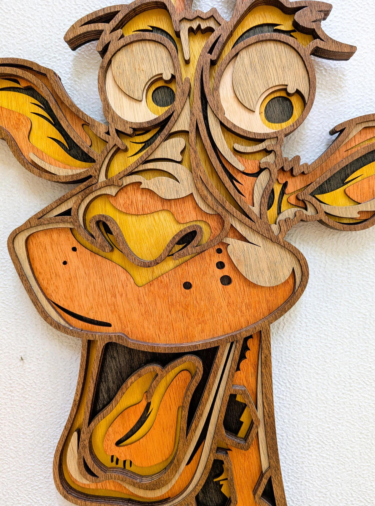 3D Fun Giraffe wood wall art with layered natural wood, orange and yellow tones, oversized eyes and playful grin