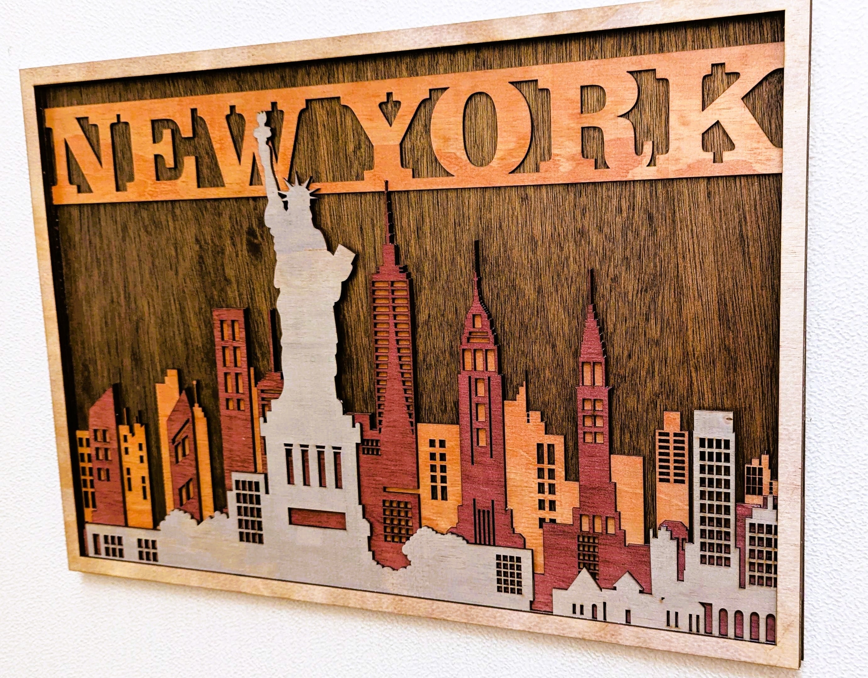 Wooden wall art of New York city skyline with 'New York' at the top.