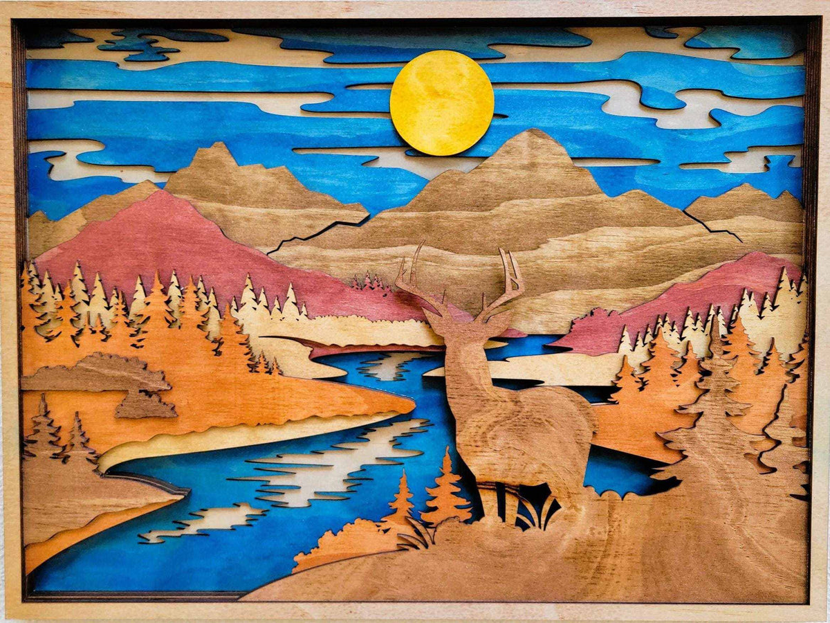 Deer & Mountain Scene layered wood wall art with a natural wood buck, blue river, pine forest, mountains, and yellow sun