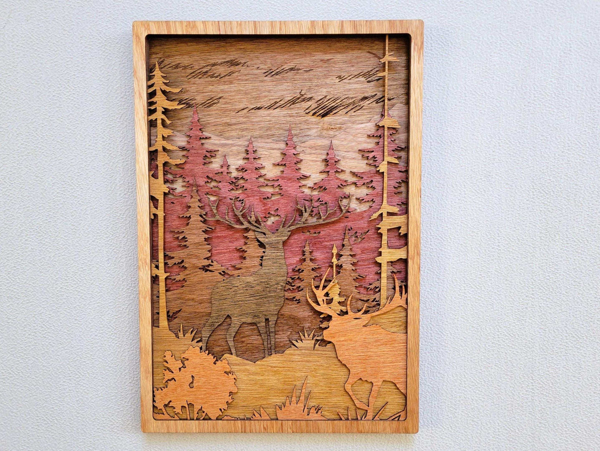Elk & Buck Woodland Forest Wall Art, layered natural wood panel with carved elk, buck, pine trees, and pink forest tones