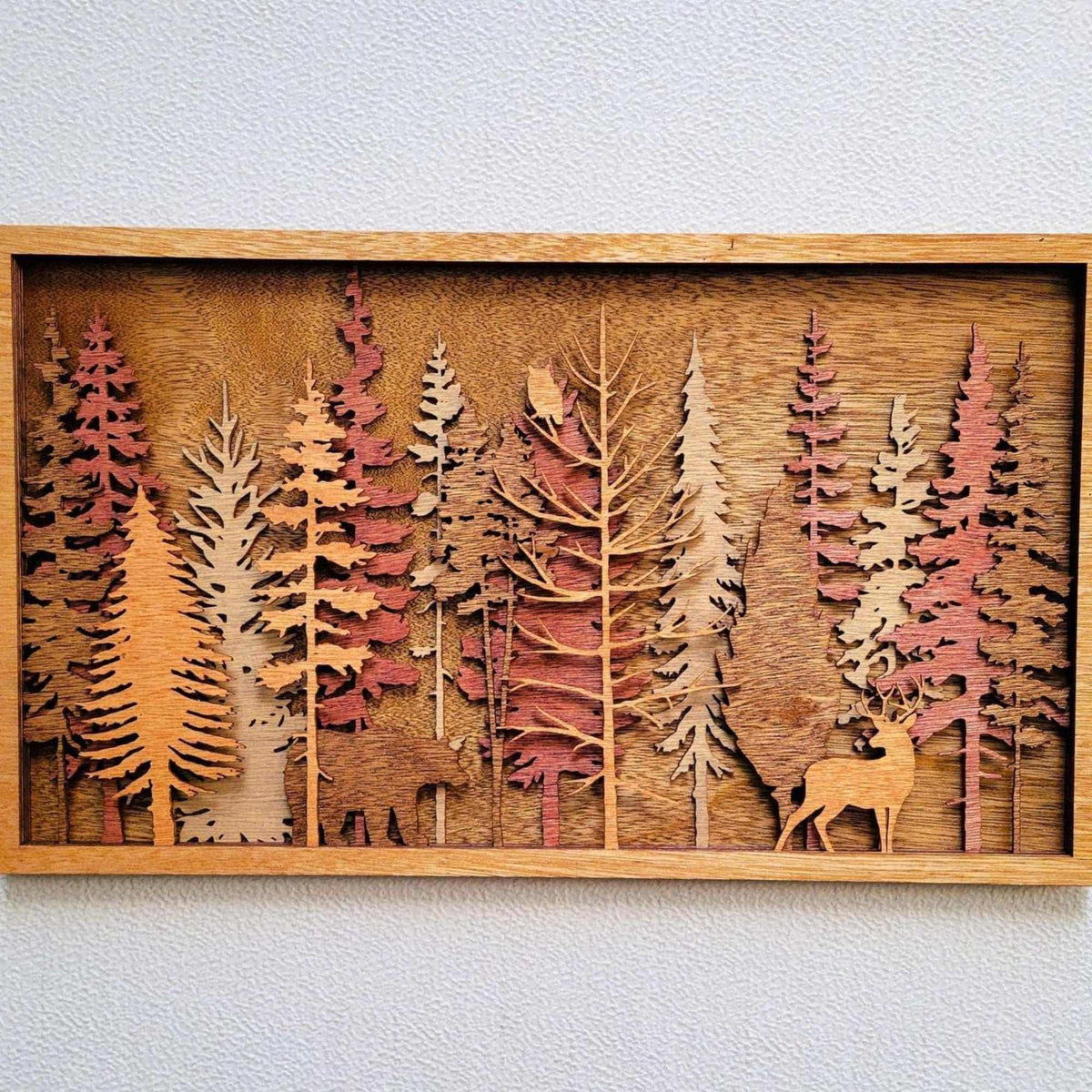 Handcrafted wood art forest wall panel in warm brown and natural tones, layered pine trees and a deer