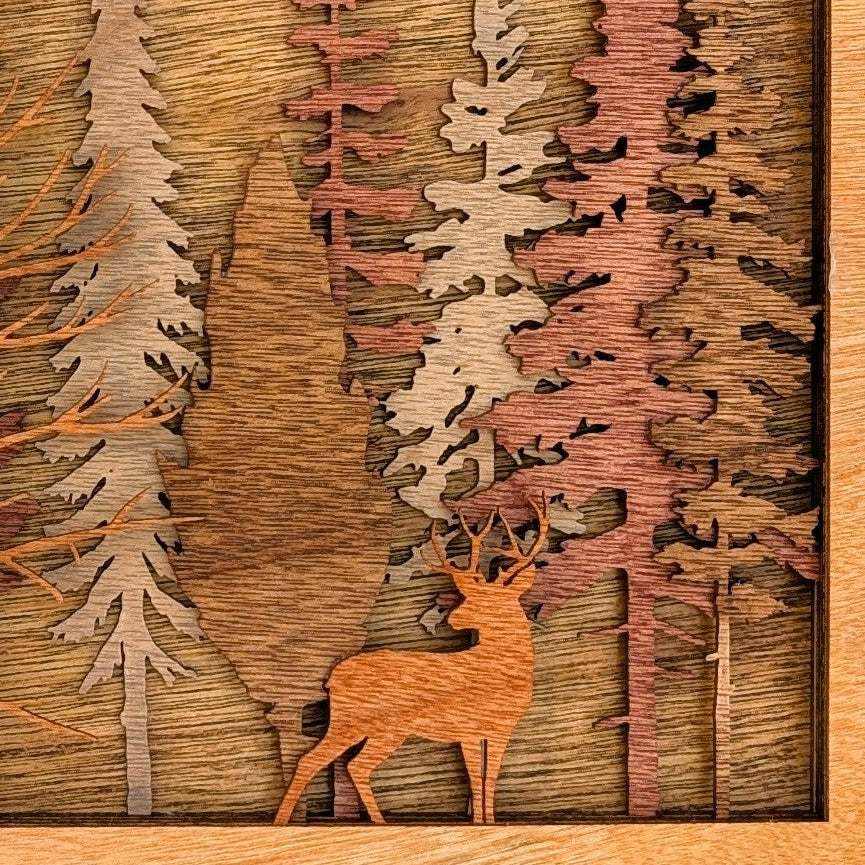 Handcrafted wood art featuring a layered forest scene with a warm brown buck among carved trees