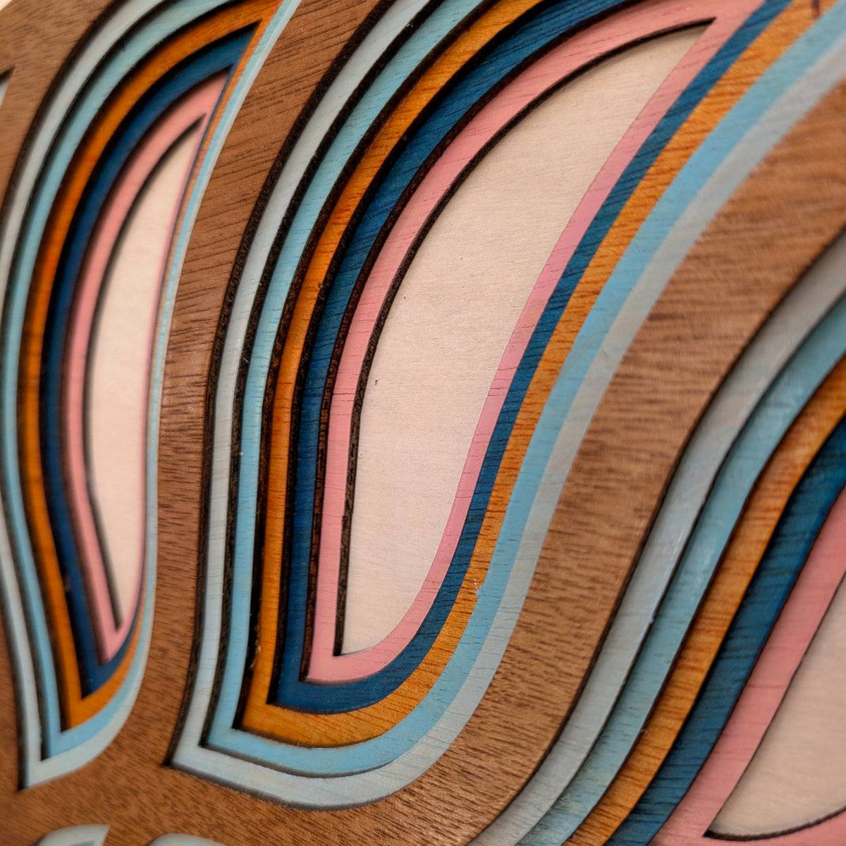 Layered nautilus shell wood wall art with coastal ocean decor colors and intricate spiral design