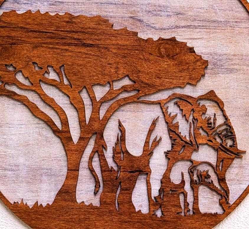 Handcrafted wooden jungle scene featuring mama and baby elephants beneath an African acacia tree.