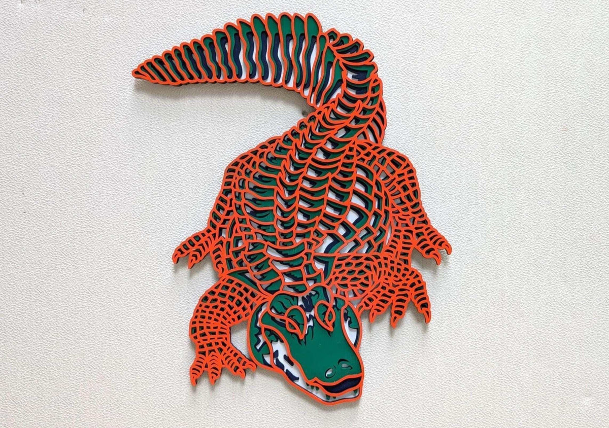 Layered Alligator Wall Art featuring a green and navy alligator with orange-edged wooden scales and curled tail