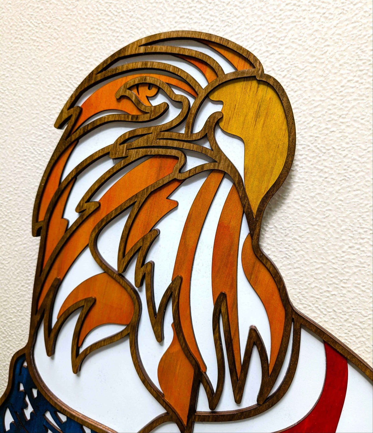 Layered Bald Eagle Wood Wall Art in golden and orange wood with flowing red, white, and blue flag details