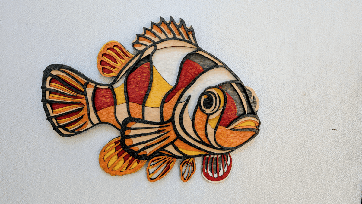 Handcrafted layered clownfish wood wall art in vibrant coastal colors