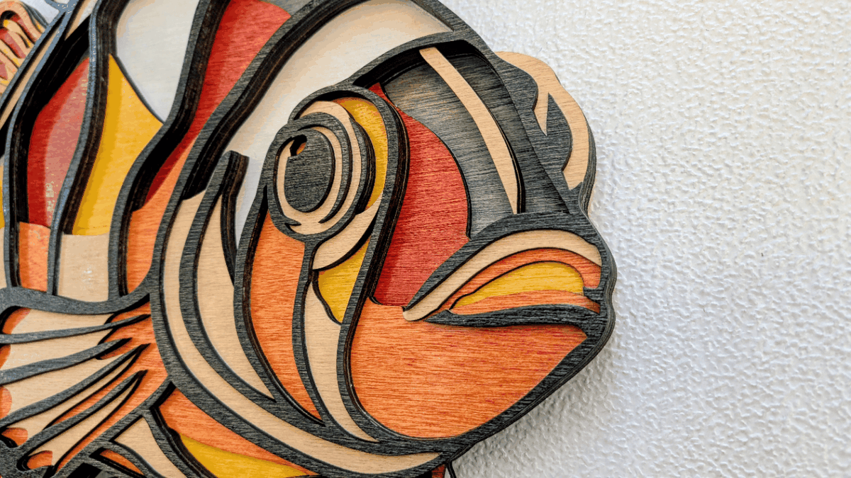 Colorful layered clownfish wood wall art with vibrant coastal colors