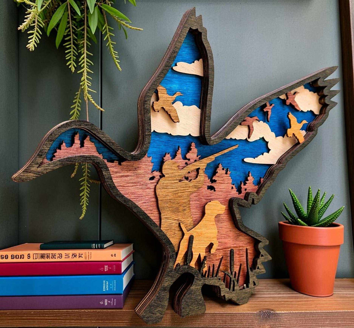 Layered Duck Hunting Wood Wall Art featuring a blue duck silhouette with a multicolour hunter, dog and marsh scene
