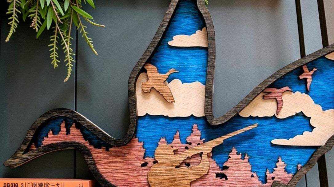 Layered Duck Hunting Wood Wall Art in blue and natural wood, featuring a hunter, flying ducks, clouds, and pine trees