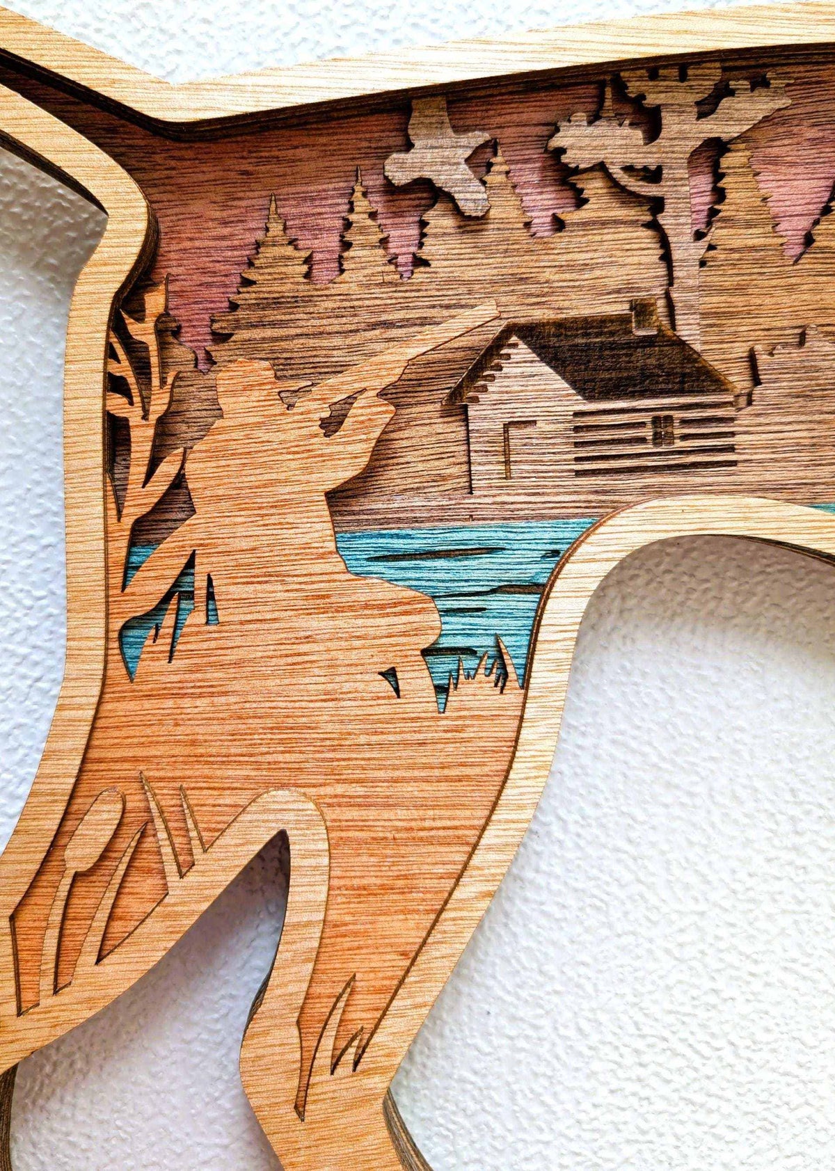 Layered Hunting Dog Wood Wall Art featuring a natural wood dog silhouette with cabin, blue water, trees, and mountains