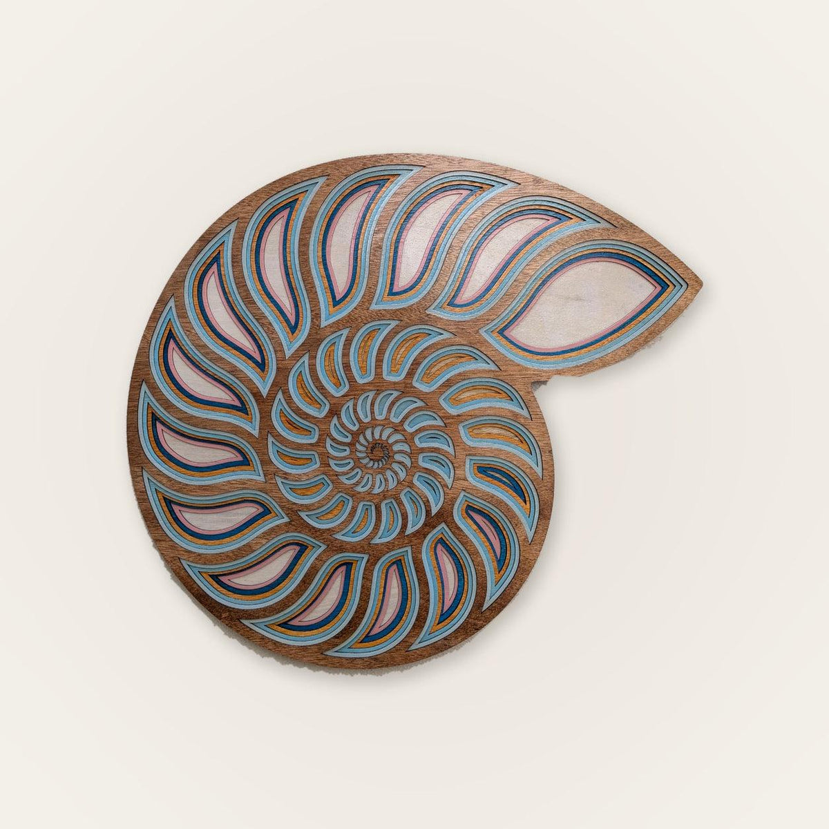 Layered nautilus shell wood wall art with coastal ocean decor colors and natural wood grain