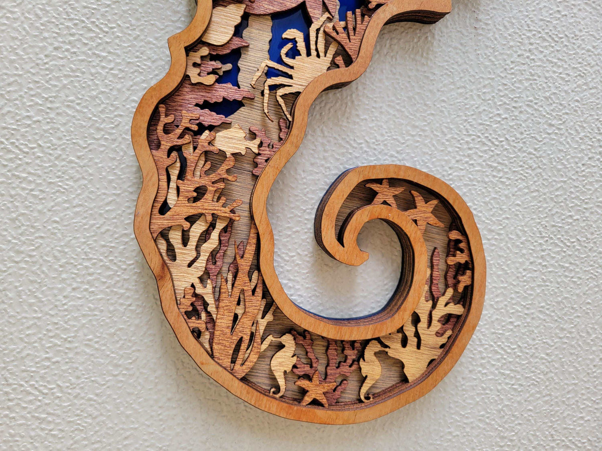 Layered Seahorse Wood Wall Art in natural wood tones, featuring intricate marine-life cutouts and a curled tail