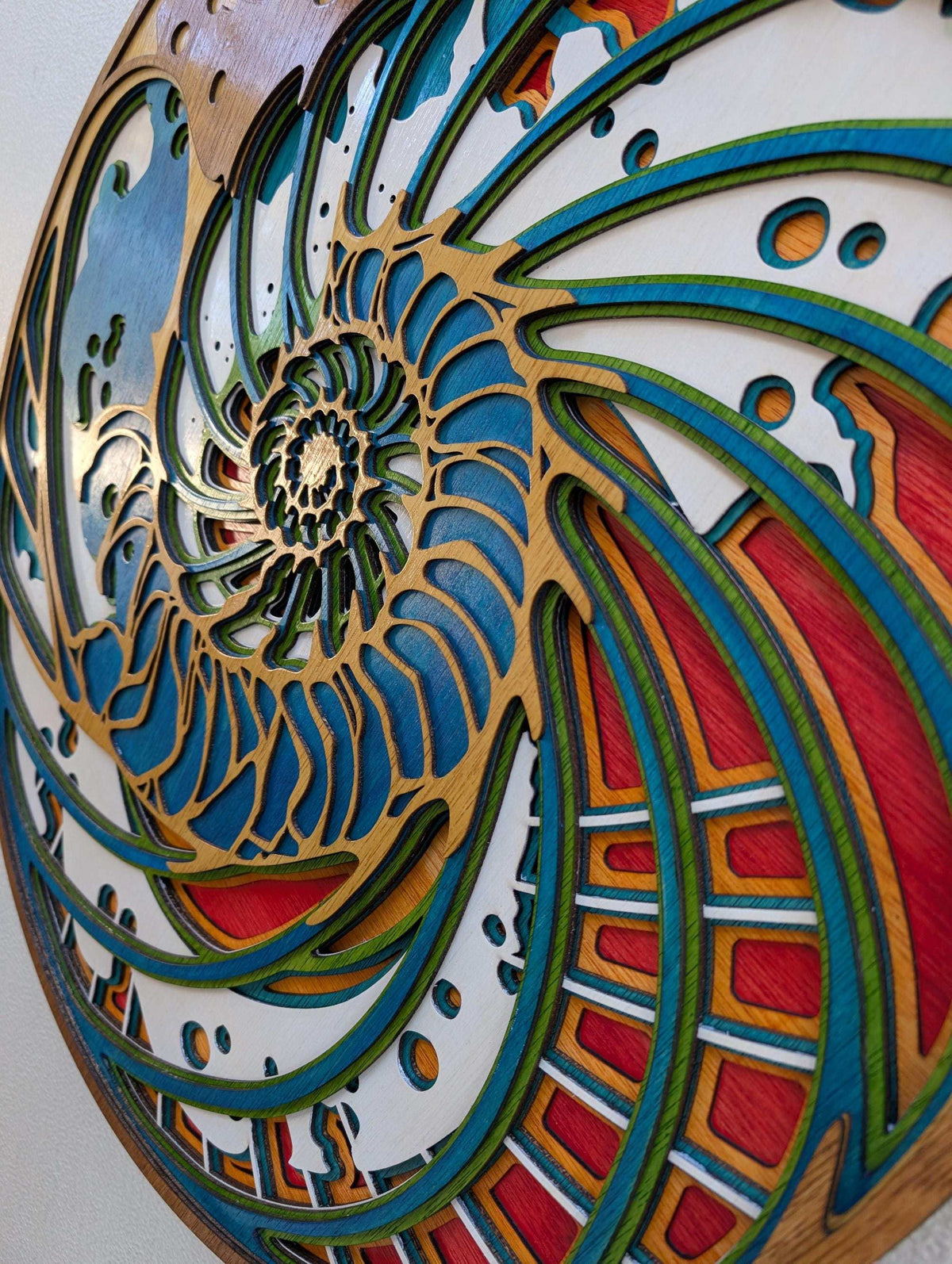 Handmade layered wood nautilus shell wall art with vibrant coastal colors